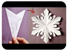 someone is making a snowflake out of paper