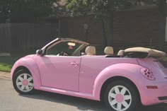 a pink convertible car parked in front of a house