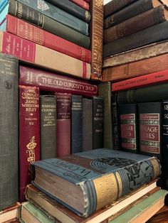a stack of books sitting on top of a wooden shelf