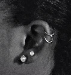 a close up of a person's ear with two piercings