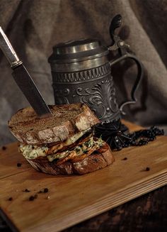 a sandwich on a cutting board with a knife