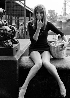 black and white photograph of a woman sitting on a bench