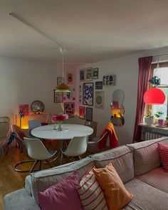 a living room filled with furniture next to a window covered in lots of pictures on the wall