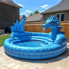 an inflatable pool with a dragon shaped water feature on the side and a brick patio behind it