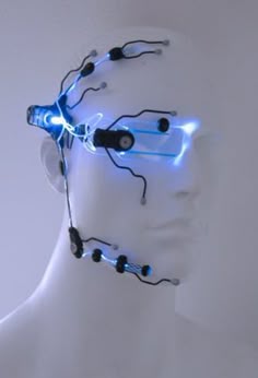 a white mannequin head with blue and black wires attached to it's face