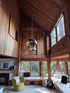 a living room with wood paneling and large windows on the side of the wall