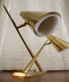 a gold desk lamp on a wooden floor