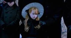 a group of people standing next to each other with hats on and one woman wearing a white hat