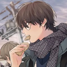 a man eating food while standing next to another man in front of a cable car