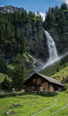 a house in the mountains with a waterfall coming out of it