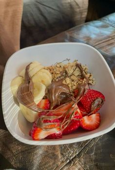 a white bowl filled with chocolate covered strawberries and bananas