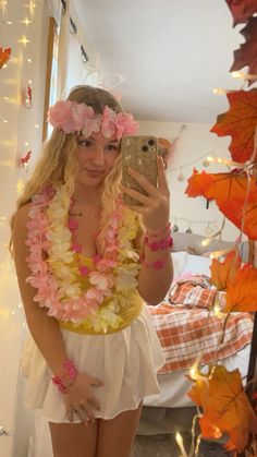 a woman taking a selfie in front of a mirror with flowers on her head