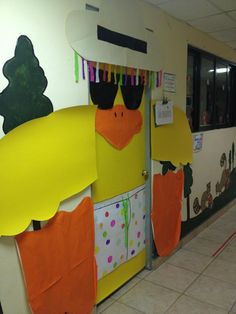 a hallway decorated with yellow and orange paper cutouts that look like ducks wearing sunglasses