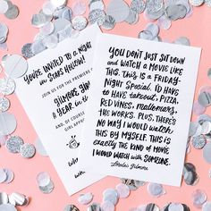 two white paper cards with silver confetti scattered around them on a pink background