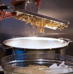 someone is cooking pasta in a pot on the stove