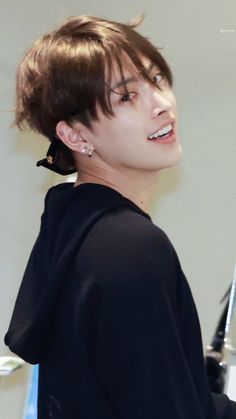 a young man with brown hair and black shirt