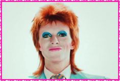 a man with red hair and blue eyes is wearing a green suit, tie and leopard print shirt