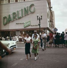 two women walking down the street in front of a building with a sign that says darling