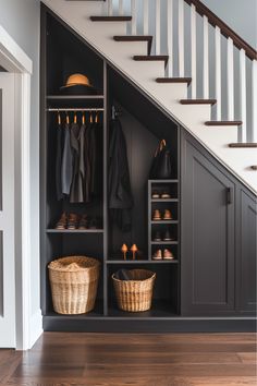 an open closet under the stairs with baskets and shoes