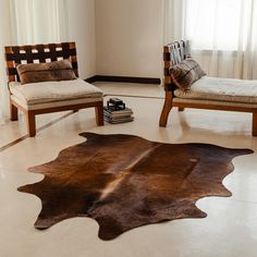 a living room with two chairs and a cow hide rug