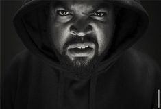 a man with a hoodie on is looking at the camera and has an angry look