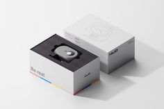 an open box with a camera inside on a white surface next to another box that has the same object in it