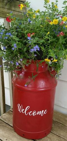 a red metal barrel with flowers growing out of it