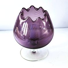 a purple glass vase sitting on top of a table