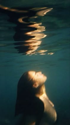 a woman is swimming in the water with her head above the water's surface