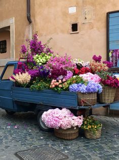 a blue truck filled with lots of flowers