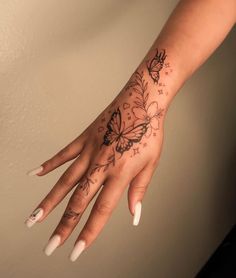 a woman's hand with a butterfly tattoo on it