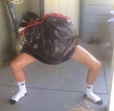 a woman is standing on one leg with a trash bag over her head