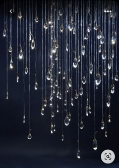 a chandelier hanging from the ceiling with drops of water coming out of it
