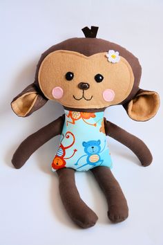 a stuffed monkey wearing a blue and brown shirt