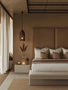 a bedroom with a large bed and lots of pillows on the headboard, along with two side tables