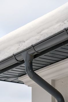 the gutter hose is attached to the side of a building with snow on it