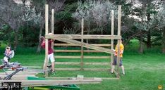 two men working on a wooden structure in the grass