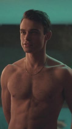 a shirtless man with no shirt standing in front of a wall and looking at the camera