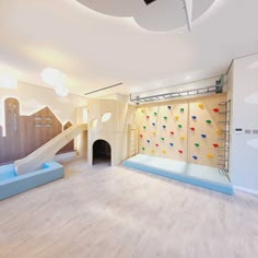 an indoor climbing wall and play area in a children's room with wooden flooring