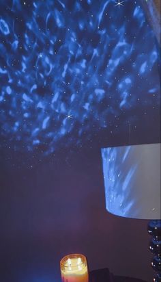 a room that has a large screen on the wall and a candle in front of it