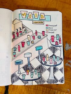 an open book with drawings on it sitting on top of a wooden table next to a pen