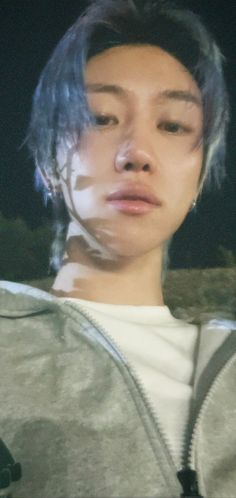 a woman with blue hair is looking at the camera