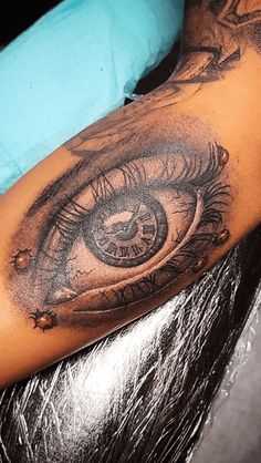 a man's arm with an eye tattoo on it