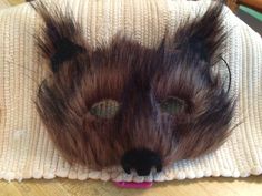 a stuffed animal that is laying on top of a table with its eyes open and hair in the shape of a bear's head