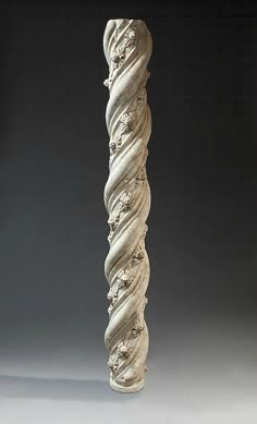 a tall white vase sitting on top of a table