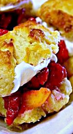 a close up of a plate of food with biscuits and fruit on it, including strawberries