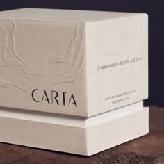 two white boxes sitting on top of a wooden table next to each other with the words carta printed on them