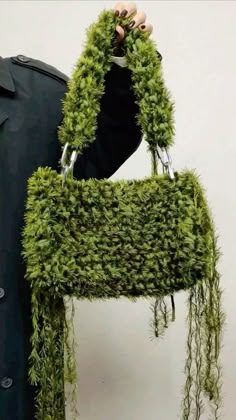 a piece of furniture made out of green plants and metal handles is shown in front of a white wall