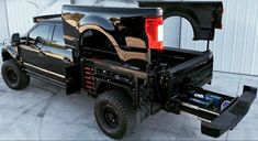 the truck is parked in front of a building and has its bed opened to allow it to