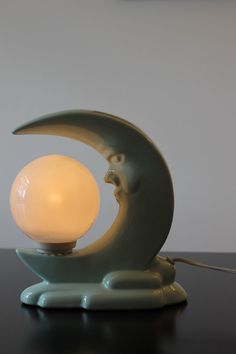 a lamp that is sitting on top of a table with a light bulb in the shape of a moon